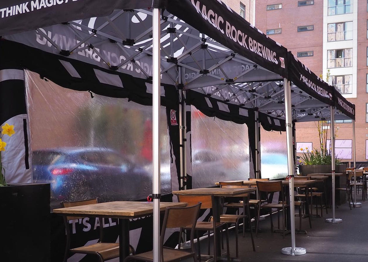 Outdoor dining area covered with pop up gazebos