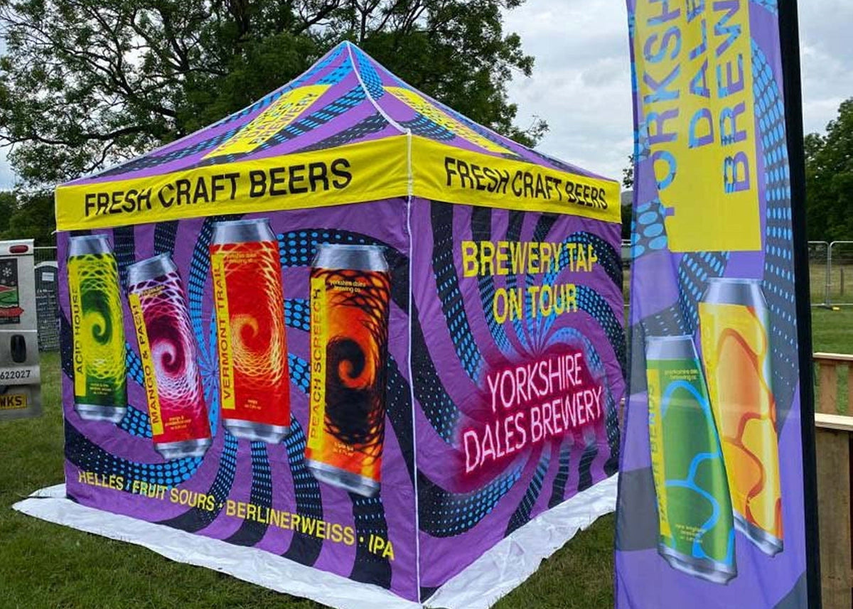 A eye catching colourful custom printed gazebo and feather flag selling beer at a outdoor festival.