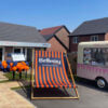 Giant custom-printed deckchair with Bellway branding, positioned outside a sales centre at an outdoor promotional marketing event.