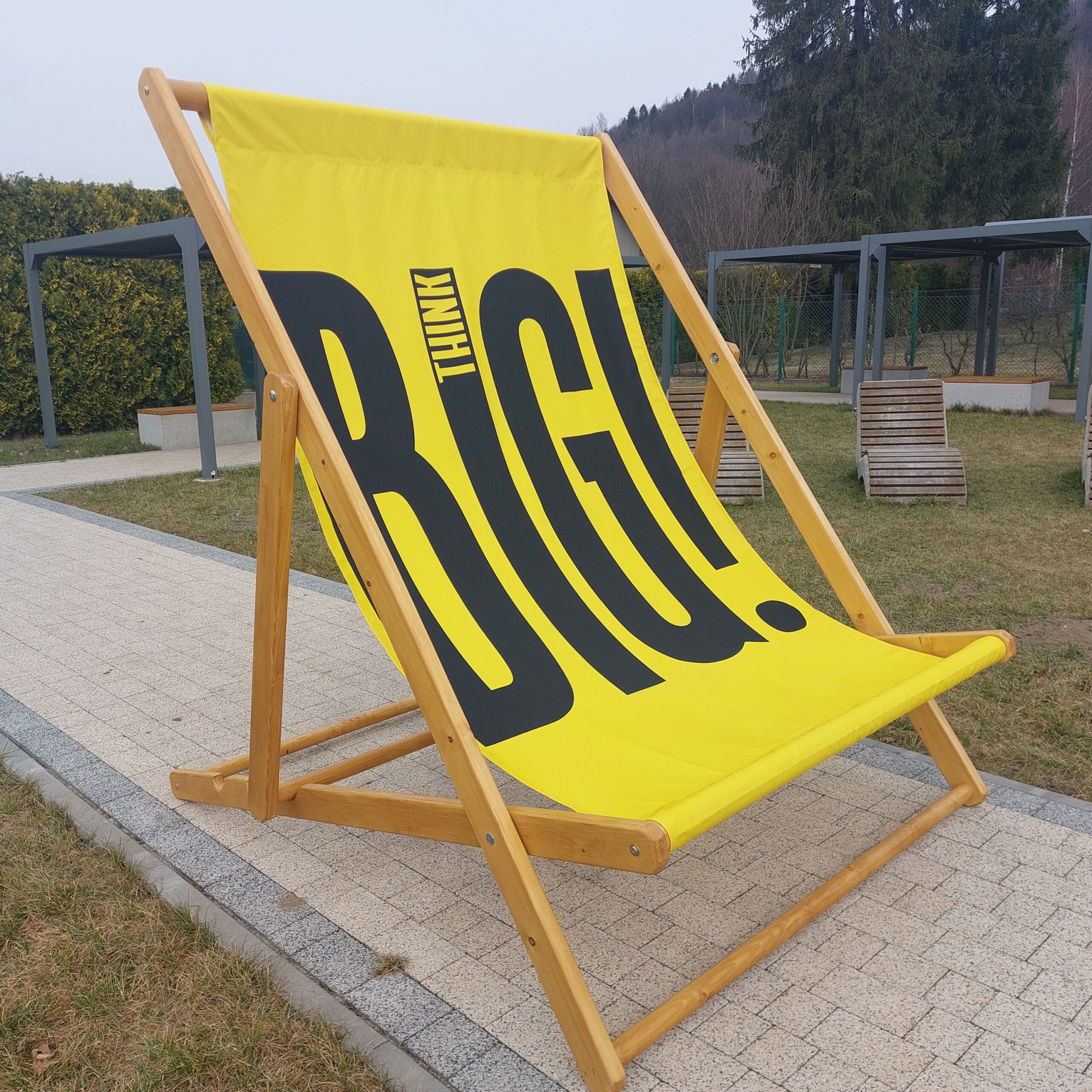 Giant custom printed deckchair featuring 'THINK BIG' branding, set up outdoors on a paved walkway at an event